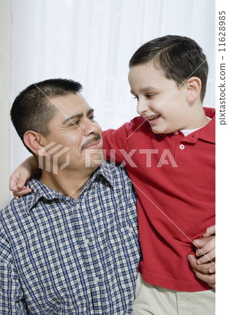 Hispanic father and son hugging 11628985