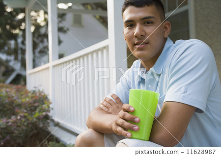 Hispanic man sitting on porch Hispanic man sitting on porch 11628987