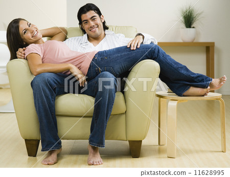 Multi-ethnic couple sitting on chair 11628995