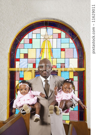 African American father holding babies in church 11629011