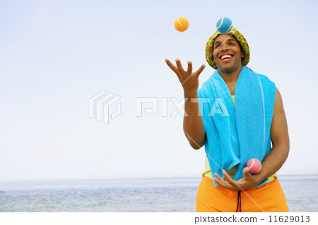 Hispanic man juggling at beach 11629013