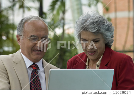 Senior Hispanic couple looking at laptop Senior Hispanic couple looking at laptop 11629034