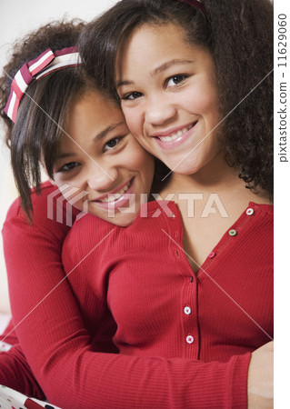 African twin sisters hugging 11629060