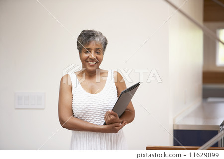 Senior African businesswoman holding paperwork 11629099