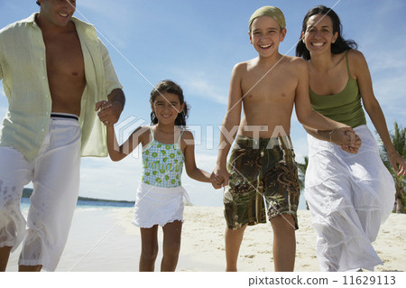 Hispanic family holding hands at beach Hispanic family holding hands at beach 11629113