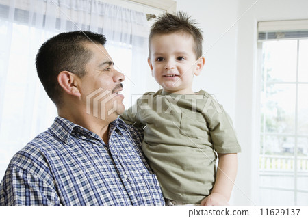 Hispanic father and son hugging 11629137