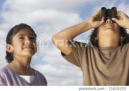 Hispanic boy looking through binoculars 11629153