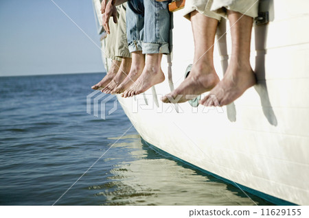 Bare feet hanging over side of boat 11629155