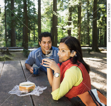 Indian couple eating lunch in woods Indian couple eating lunch in woods 11629210