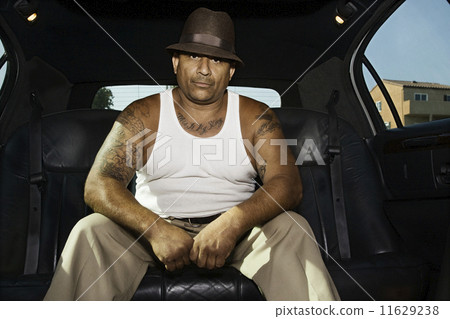 Tattooed Hispanic man in limousine 11629238