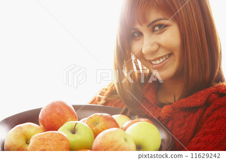Asian woman holding bowl of apples Asian woman holding bowl of apples 11629242