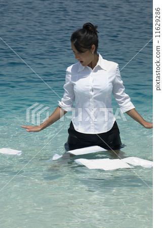 Hispanic businesswoman with papers in water Hispanic businesswoman with papers in water 11629286