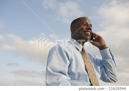 African businessman talking on cell phone African businessman talking on cell phone 11629344
