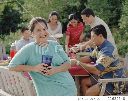Middle-aged woman smiling for the camera at a barbecue Middle-aged woman smiling for the camera at a barbecue 11629348