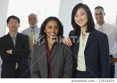 Two businesswoman with co-workers in the background 11629354