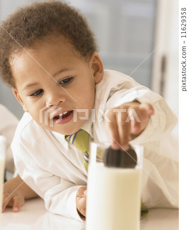 African boy dunking cookie in milk African boy dunking cookie in milk 11629358