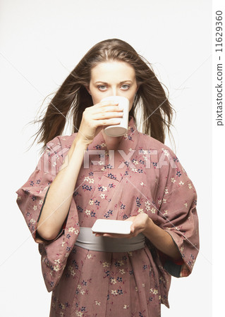 Portrait of woman wearing kimono drinking tea Portrait of woman wearing kimono drinking tea 11629360