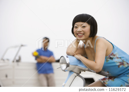 Asian woman sitting on motor scooter 11629372