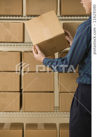 Mature man stacking cardboard boxes Mature man stacking cardboard boxes 11629380
