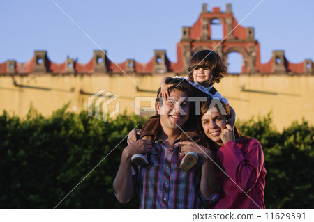 Hispanic parents holding son on shoulders 11629391