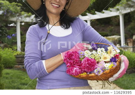 Hispanic woman holding basket of flowers Hispanic woman holding basket of flowers 11629395