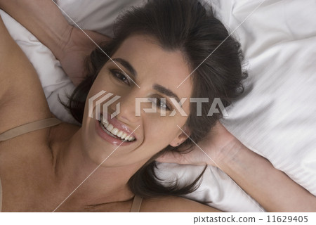 Hispanic woman with hands behind head Hispanic woman with hands behind head 11629405