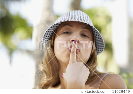 Hispanic woman kissing finger Hispanic woman kissing finger 11629449
