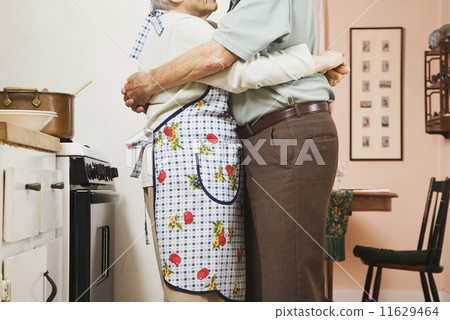 Senior couple hugging in kitchen Senior couple hugging in kitchen 11629464
