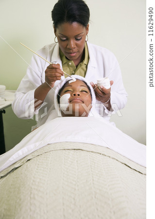 African woman receiving spa facial treatment 11629490