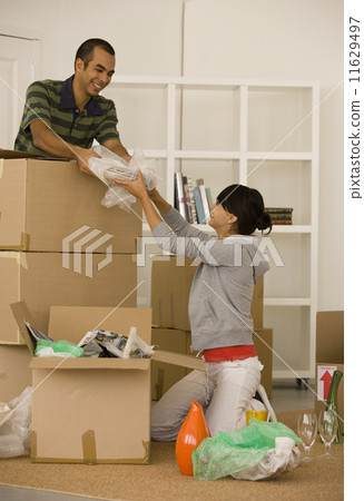 Young couple packing moving boxes Young couple packing moving boxes 11629497