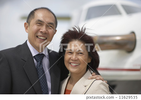 Asian couple next to airplane Asian couple next to airplane 11629535