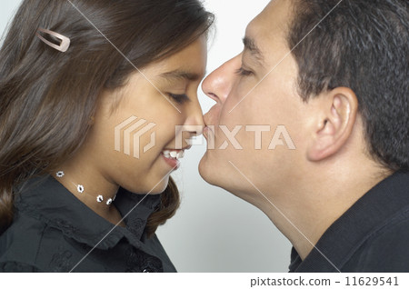 Hispanic father kissing daughter's nose 11629541