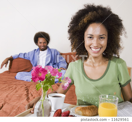 African woman carrying breakfast in bed tray 11629561