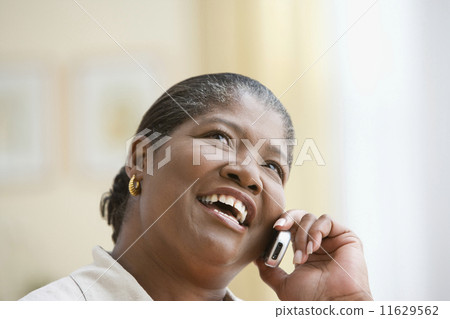 Middle-aged African woman talking on her cell phone Middle-aged African woman talking on her cell phone 11629562