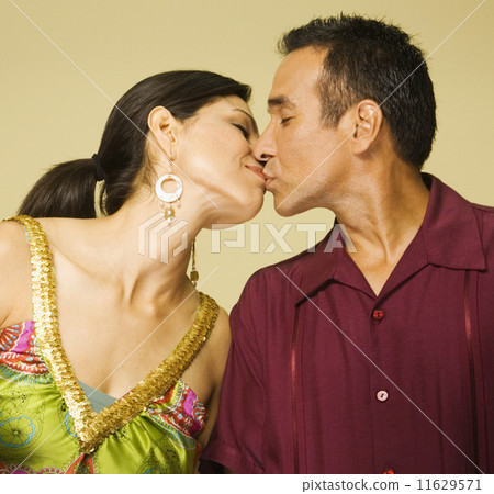 Studio shot of Hispanic couple kissing 11629571