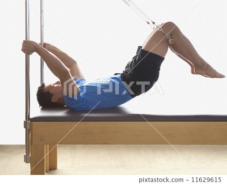 Asian man stretching on exercise equipment 11629615