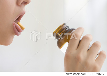 Woman with vitamin on tongue 11629617