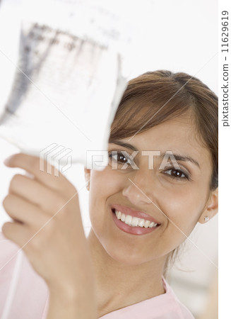 Portrait of nurse adjusting IV bag 11629619
