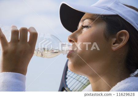 Hispanic woman drinking from water bottle Hispanic woman drinking from water bottle 11629628