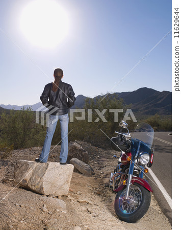 Hispanic woman standing next to motorcycle Hispanic woman standing next to motorcycle 11629644