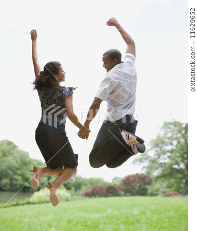 African American couple jumping in air African American couple jumping in air 11629652
