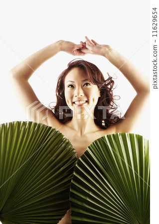 Nude Asian woman covered by large leaves Nude Asian woman covered by large leaves 11629654