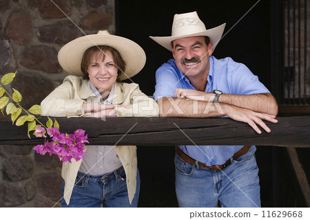 Hispanic couple wearing cowboy hats 11629668