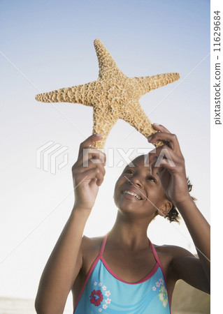 African girl holding starfish African girl holding starfish 11629684