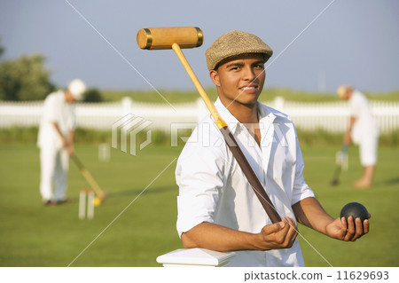 Hispanic man playing croquet Hispanic man playing croquet 11629693