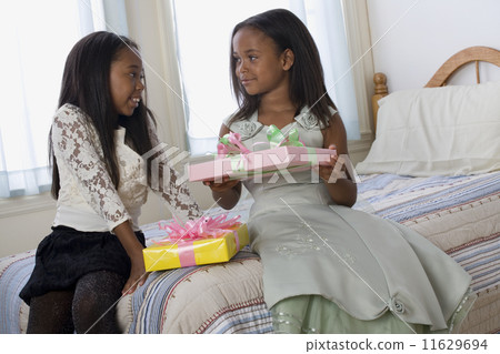 African American sisters exchanging gifts 11629694