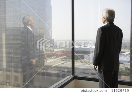 Senior businessman looking out a window Senior businessman looking out a window 11629719