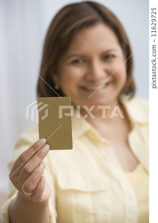 Hispanic woman holding up card 11629725