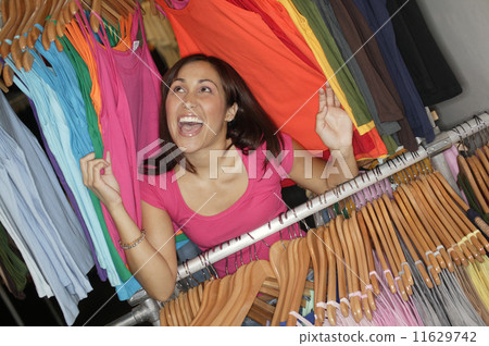 Woman in rack of clothing Woman in rack of clothing 11629742