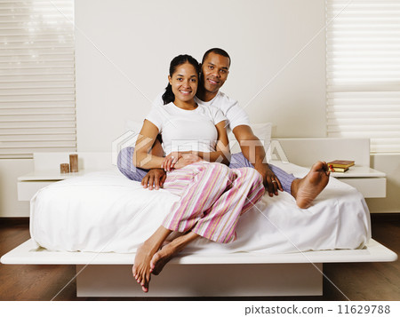 African couple sitting on bed African couple sitting on bed 11629788